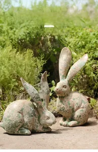 Detalle de estatuas de conejo de resina vintage con textura verde envejecida para jardín