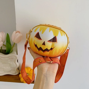 Detail of a round orange pumpkin crossbody bag with Jack-o'-lantern face and matching strap