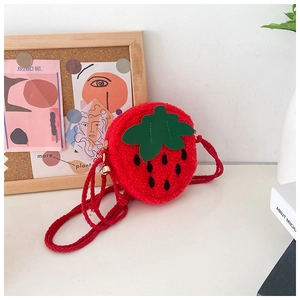 Detailed view of a red plush strawberry crossbody bag with green leaves and black seeds