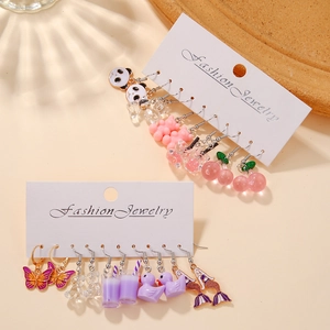 Détail de breloques mignonnes en résine avec boucles d'oreilles panda, ours et cerise