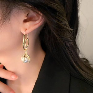 Modern gold geometric earrings with pearl charms worn on a female model for fashion style