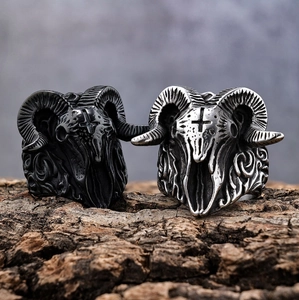 Gothic punk ram skull rings in matte black and vintage silver on rustic wood base