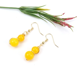 Detail of handmade gold wire drop earrings featuring polished yellow crystal beads