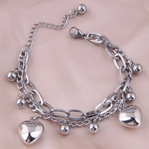 Close-up of silver double-layered stainless steel bracelet with heart pendants on silk