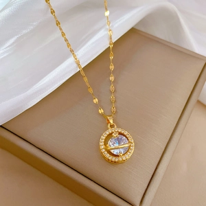 Elegant gold titanium planet necklace with white zircon pendant on beige jewelry box