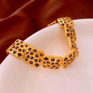 Détail d'un bracelet vintage à maillons carrés avec émail léopard et fini doré brossé