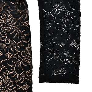 Close-up of black floral lace fabric with nude lining and sheer hollow texture details