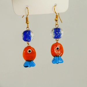 Detailed view of handmade fish-shaped glass earrings with vibrant orange and blue colors