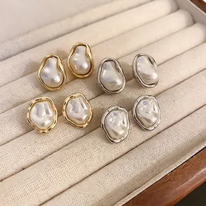 Irregular Baroque pearl stud earrings with gold and silver frames in a jewelry box