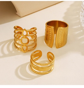 Detail view of gold geometric and bohemian leaf rings with engraved textures