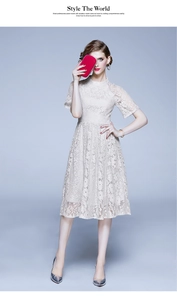 Détail de la broderie en dentelle florale et du col montant sur cette robe midi abricot