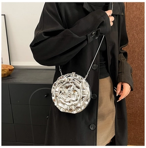 Detailed view of silver rose-shaped hard shell clutch bag with metallic flower relief