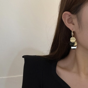 Detail view of vintage multi-layered gold and silver round fringe earrings on a model