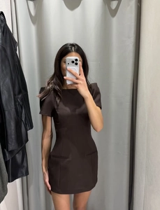 Mirror selfie showing the detail of a brown puff sleeve mini dress in a slim fit style