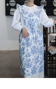 Detail of French vintage floral apron with blue Toile de Jouy pattern and ruffle trim