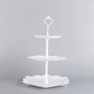 Three-tier white plastic dessert stand with elegant embossed floral edges and top handle