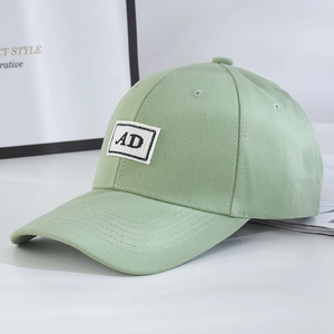 Close-up of light green twill cotton baseball cap with a white AD letter patch detail