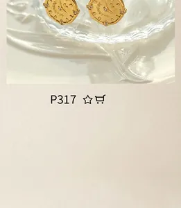 Close-up of vintage gold-plated clock face stud earrings on a wavy white tray