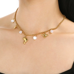 Close-up of gold stainless steel necklace with ocean charms and pearls on model