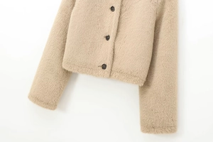 Close-up of beige faux fur jacket fabric texture and brown round button detail