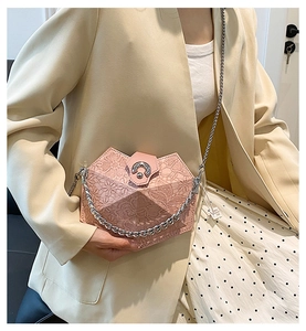 Pink lace geometric crossbody bag with metal chain strap styled on a beige suit and polka dot dress