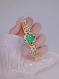 Detail of luxury ladies watch with green dial and gold diamond-encrusted bracelet