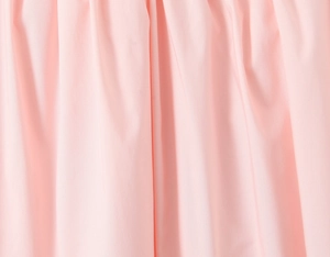 Dettaglio del tessuto rosa morbido con pieghe eleganti e design a balze della gonna