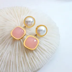 Elegant gold earrings with square pink stone and white faux pearl on white coral
