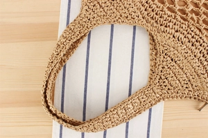 Close-up of the handcrafted paper rope weave and sturdy handle on this woven tote bag