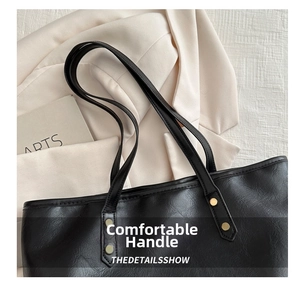 Close-up of black PU leather tote bag with grainy texture and golden rivet accents