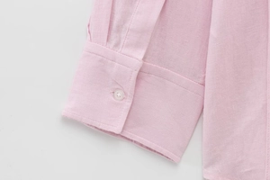 Detailed macro shot of pink long sleeve shirt cuff showing fine cotton fabric texture