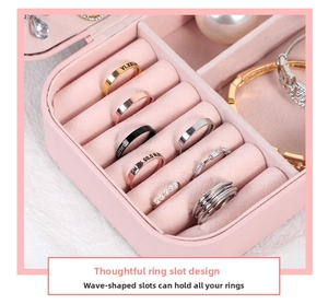 Macro view of wave-shaped ring slots with soft velvet lining in pink jewelry box