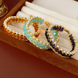 Detailed view of beaded titanium steel bracelets with pearls in amber, mint, and purple