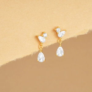 Close-up of gold drop earrings with sparkling white teardrop and round zircons