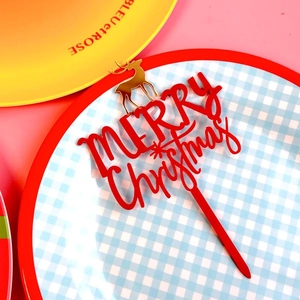 Detail of red and gold Merry Christmas acrylic cake topper with reindeer silhouette