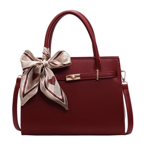 Elegant burgundy tote bag with gold lock and heart-patterned silk scarf on white background