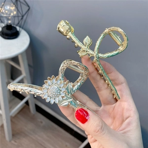 Dettaglio di fermagli per capelli con rose e girasoli decorati con brillanti strass