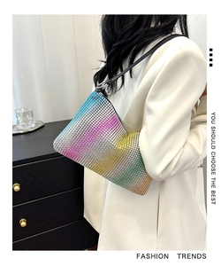 Detail of vibrant gradient rhinestone handbag with glittering surface and black strap