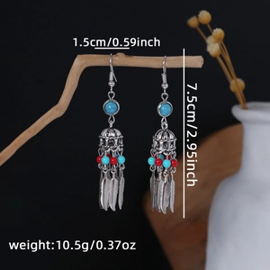 Bohemian silver drop earrings with blue stones and feather tassels on wooden branch