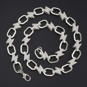 Detail of silver lightning bolt necklace with crystal rhinestones on black background