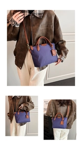 Detail shot of purple nylon tote with brown leather handles and adjustable shoulder strap