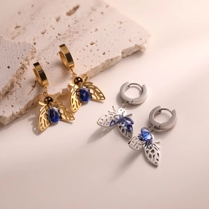 Detail of bee earrings with blue crystals in gold and silver finish on stones