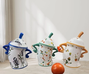 Detailed view of hand-painted ceramic canisters with colorful spots and lids in home setting