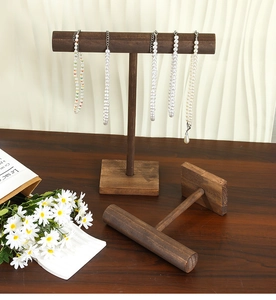 Detail view of two dark vintage wood T-bar stands for necklaces and bracelets