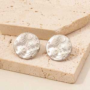 Detail of 304 stainless steel disc earrings with celestial sun and moon relief patterns