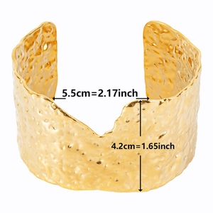 Macro shot showing dimensions of wide hammered gold cuff bracelet in 18k plated steel