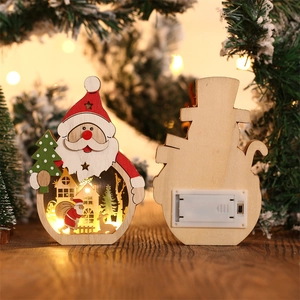 Détail du décor Père Noël LED en bois montrant le design creux et le boîtier à piles