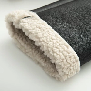 Detailed macro shot of faux leather jacket cuff with thick cream faux fur lining