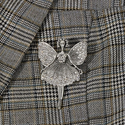 Macro shot of silver dancer brooch with sparkling rhinestones on a plaid suit lapel