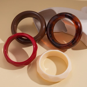 Minimalist acrylic resin geometric bangles in red, amber, and cream colors